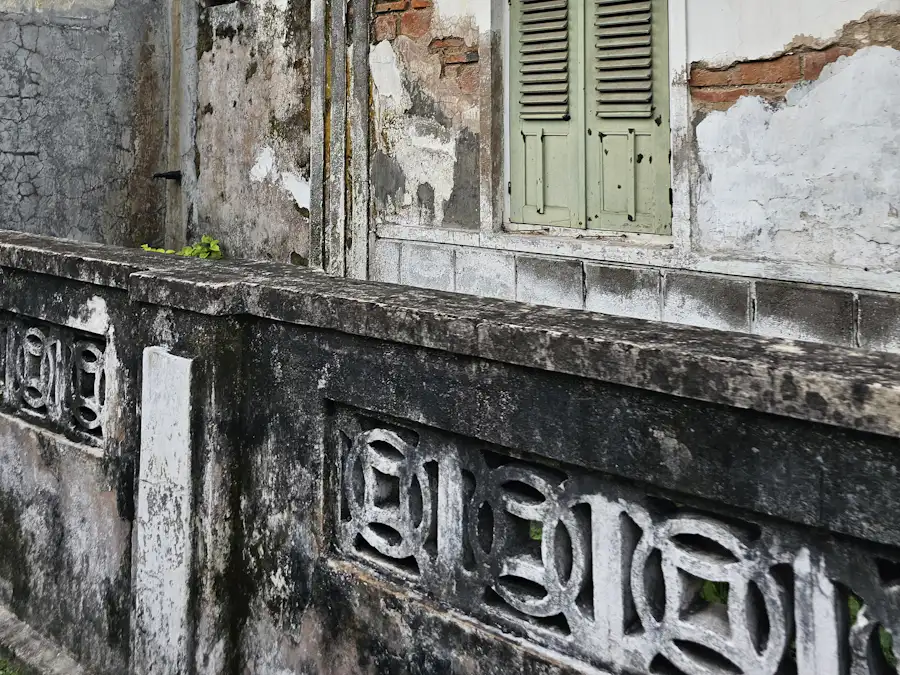 Weathered colonial-era masonry with a green shuttered window