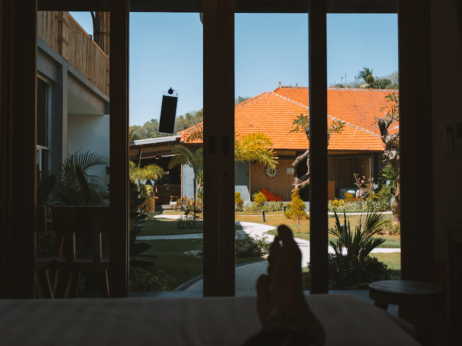 Looking out from inside a tropical bungalow towards a tiled-roof building