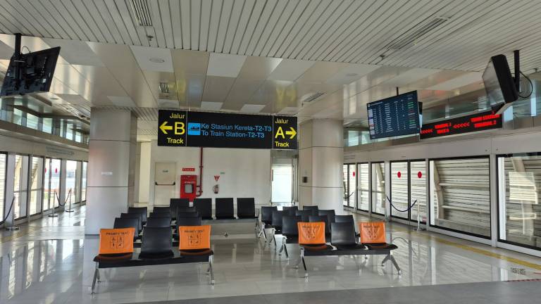 An empty airport waiting area with seating and departure displays