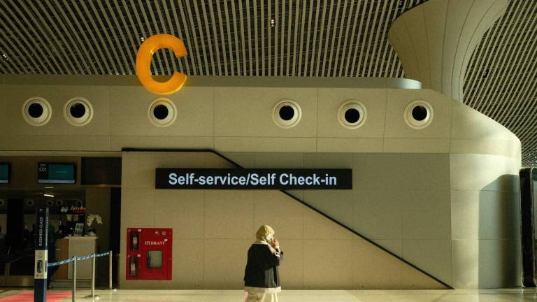 A traveller walking past the self check-in area of an Indonesian airport