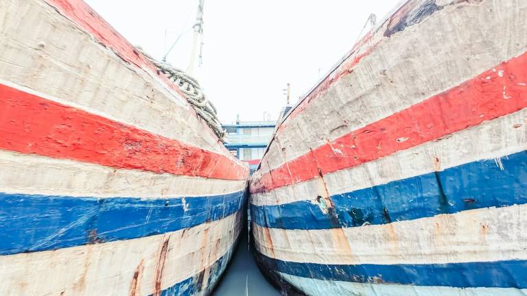 The painted bows of two Indonesian passenger ships at a pier