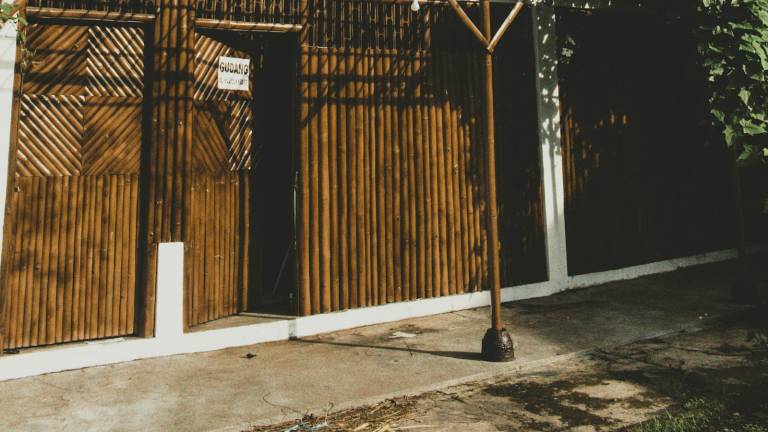 A timber and woven-bamboo building among trees in Indonesia