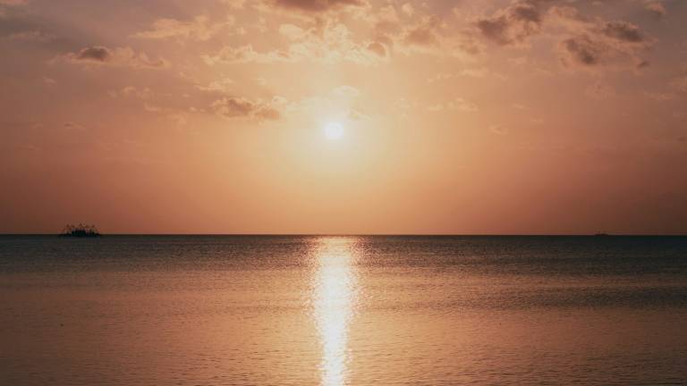 The sun low over a calm sea in Maluku